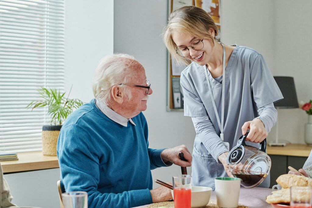 Caregiver pouring coffee for senior man